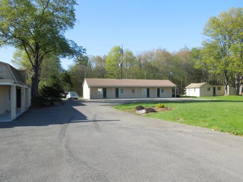 a house with a car parked in front of a driveway at Value Inn East Stroudsburg in Marshalls Creek