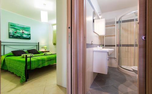 アルゲーロにあるAlghero Villa Morena with exclusive swimming pool and large gardenのベッドルーム(緑のベッド1台、シンク付)