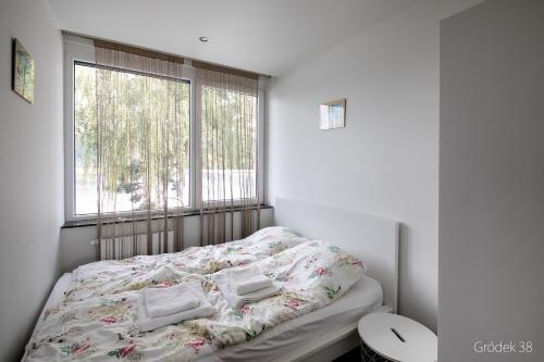 a small bedroom with a bed with a window at Apartment Słoneczny Gródek 38 in Gródek Nad Dunajcem