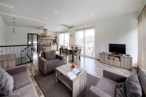 a living room with a couch and a table at Apartment Słoneczny Gródek 38 in Gródek Nad Dunajcem
