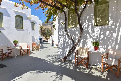 a patio with chairs and tables in front of a building at Giannakas Studios in Platis Yialos Sifnos