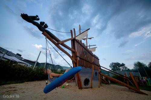 a boy on a swing in a playground at Apartment Słoneczny Gródek 38 in Gródek Nad Dunajcem