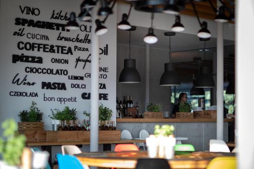 a restaurant with tables and chairs and signs on the wall at Apartment Słoneczny Gródek 38 in Gródek Nad Dunajcem