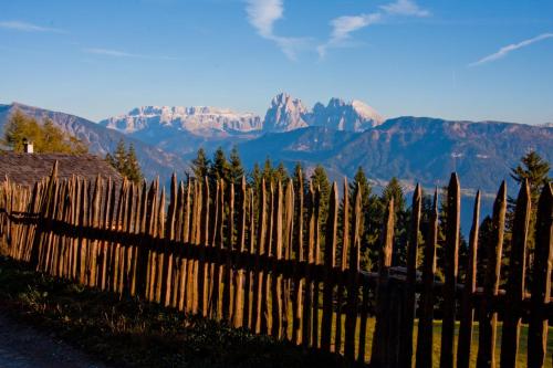 a wooden fence with mountains in the background at Schweiggerhof -Agriturismo- Farm Holidays in Villandro