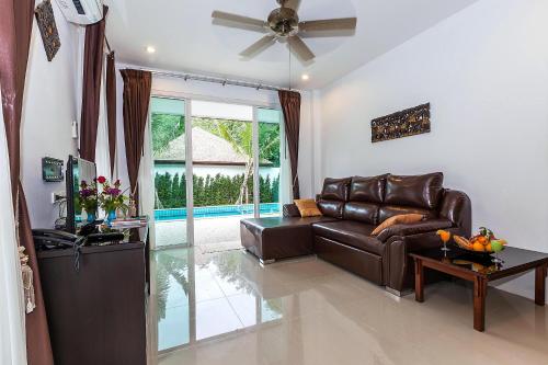 a living room with a leather couch and a table at Lux Family Villas - FREE SHUTTLE SERVICE TO THE BEACH in Ao Nang Beach