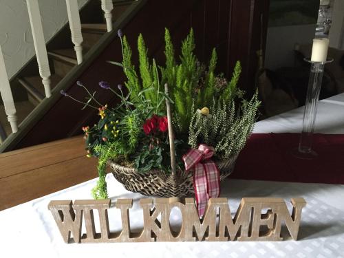 a vase of flowers on a table with a sign that says woman at Wassermühle Eldingen in Eldingen