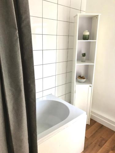 a white bath tub in a bathroom with a shelf at Castleton townhouse in Belfast