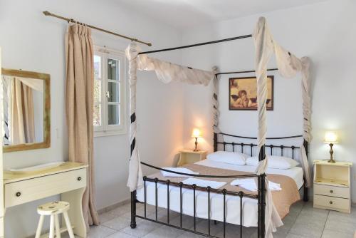 a bedroom with a four poster bed in a room at Giannakas Studios in Platis Yialos Sifnos