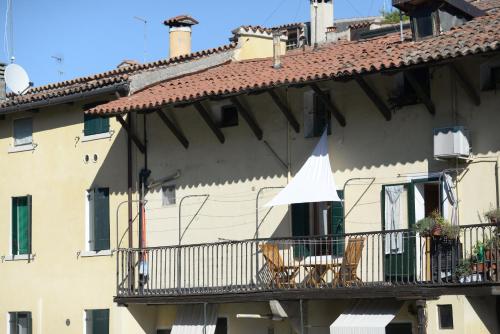 ein Gebäude mit einem Balkon mit Stühlen und einem weißen Regenschirm in der Unterkunft mansardina artista in Padua