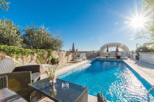 a swimming pool in a yard with a table at Apartment Crikvenica 15 in Sopaljska