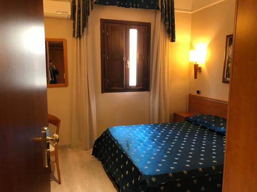 a small bedroom with a bed and a window at Bel Sito Hotel Due Torri in Manocalzati