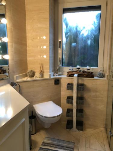 a bathroom with a toilet and a large window at Strandgut 63 in Scharbeutz