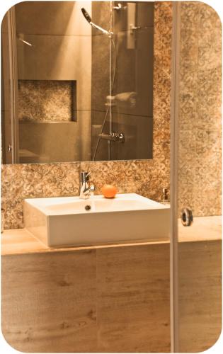 a bathroom with a white sink and a mirror at Altanahouse in Parga