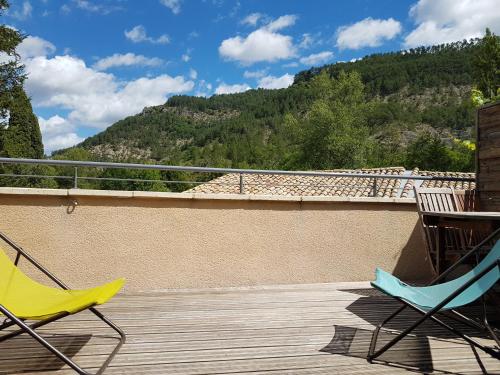 two chairs on a deck with a view of a mountain at Rue des Sophoras in Luc-en-Diois