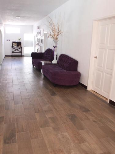a living room with two purple couches and a floor at Rancho Macloy Hotel Spa & Social Events in Yautepec