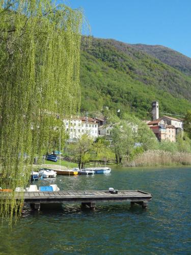 a dock in the middle of a lake with boats at Art B&B La Casa del Pittore in Revine Lago