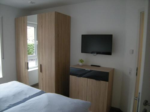 a bedroom with a bed and a flat screen tv at Norderloog in Horumersiel