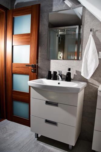 a bathroom with a white sink and a mirror at Holiday House Sabala 2 in Stará Lesná