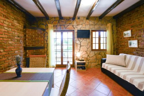 salon z kanapą i ścianą z cegły w obiekcie Villa Steffany Apartments w mieście Kolan