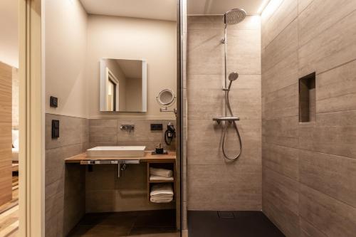 uma casa de banho com um chuveiro e um lavatório. em Hotelmyhome em Hornberg