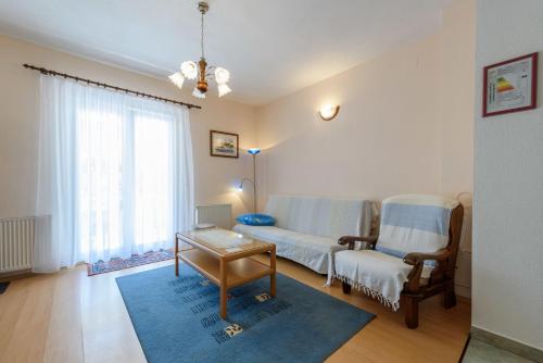 a living room with a couch and a table at Holiday home VesnaD-25m from beach in Seget Vranjica