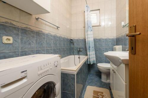 a bathroom with a washing machine and a sink at Holiday home VesnaD-25m from beach in Seget Vranjica