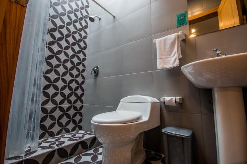 a small bathroom with a toilet and a sink at San Rocke House in Cuenca