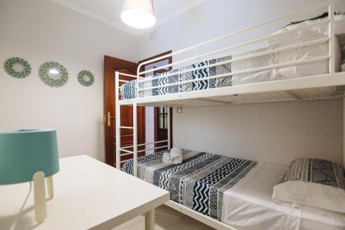 セビリアにあるApartamento centro Gran Poderのベッドルーム1室(ベッド2台、二段ベッド1組付)