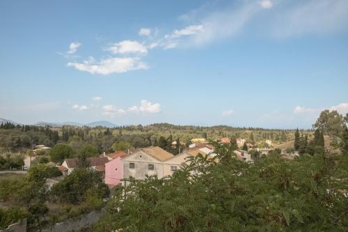 a view of a town with houses and trees at Modern flat with beautiful views in south of Corfu in Lefkímmi