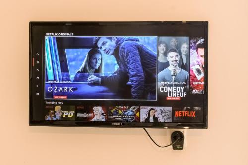 a flat screen tv hanging on a wall at Modern flat with beautiful views in south of Corfu in Lefkímmi