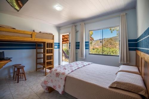 een slaapkamer met een stapelbed en een raam bij Pousada Bela Vista do Capão in Vale do Capao
