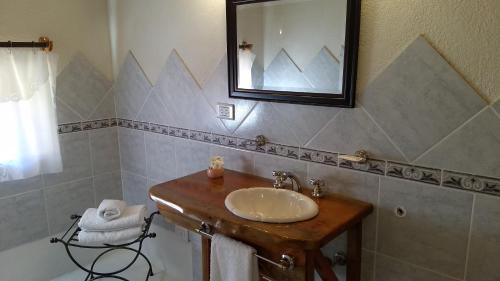 y baño con lavabo, espejo y bañera. en Apart Hotel y Hosteria del Sir, en Villa La Angostura