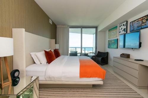 a bedroom with a large bed and a television at LYFE 4111 S Ocean dr in Hollywood