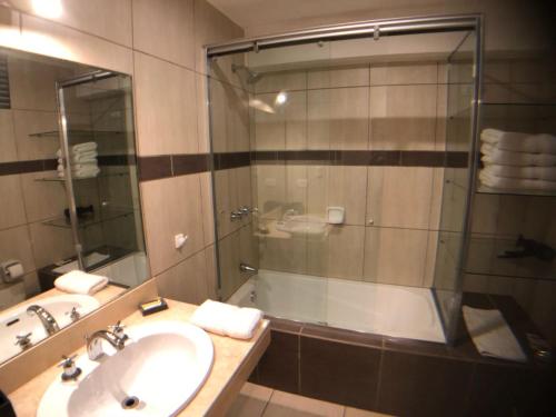 a bathroom with a shower and a sink and a tub at MLA apartments - Kennedy in Lima