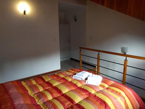 1 dormitorio con 1 cama con 2 toallas en 845 Teniente Ramayón en San Martín de los Andes