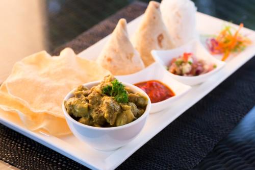 a plate of food with bowls of food and pita bread at Yatule Resort & Spa in Natadola