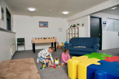 a boy and a girl playing with toys in a room at Boali Lodge Thredbo in Thredbo