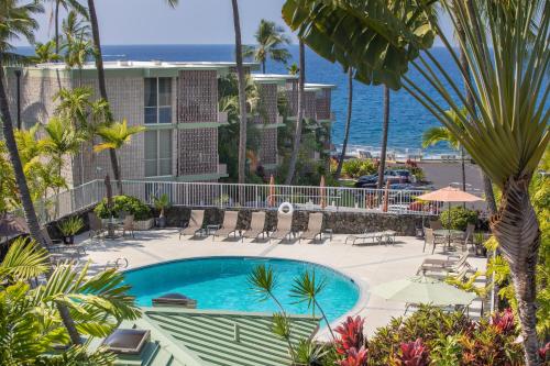 a resort with a swimming pool and the ocean at Alii Villas in Kailua-Kona