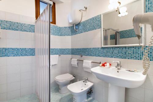 bagno con lavandino, servizi igienici e specchio di Hotel Settimo Cielo a Sorrento