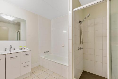 y baño blanco con bañera y ducha. en Rockhampton Riverside Central Hotel Official en Rockhampton