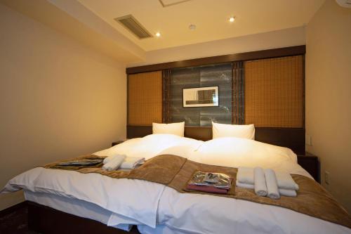 a bedroom with a large bed with white sheets at Hakone Nanase formerly known as Manatei Hakone in Hakone