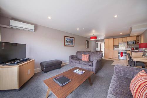 a living room with a couch and a table at Voyager Apartments Taupo in Taupo