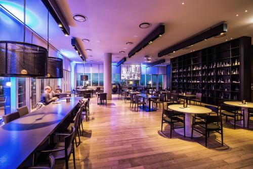 a restaurant with tables and chairs and wine racks at Shilla Stay Jeju Airport in Jeju