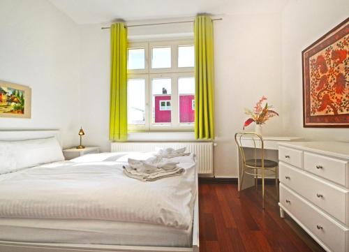 Schlafzimmer mit einem Bett und einem Fenster mit gelben Vorhängen in der Unterkunft Apartment Düne in Ahlbeck