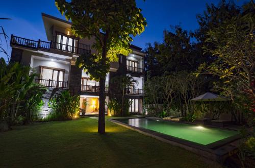 a villa with a swimming pool at night at Villa Melasti Wardana in Uluwatu