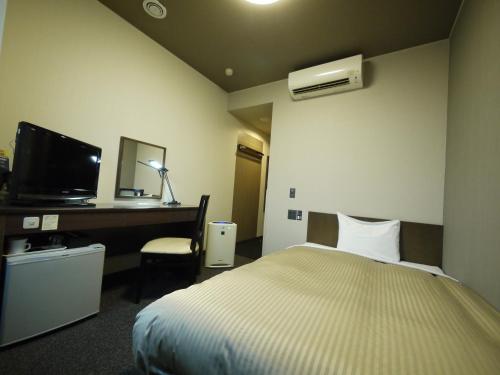 Un pat sau paturi într-o cameră la Hotel Route-Inn Court Kofu Isawa