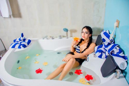 a woman sitting in a bath tub holding a drink at Santon Resort & Spa - Level 1 Certified in Tangalle