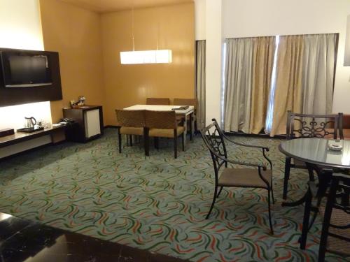a hotel room with a table and chairs and a television at Hotel Satkar Residency in Thane