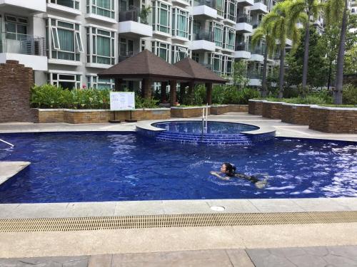 a person swimming in a swimming pool in a building at Condo at Parkside Villas across the airport in Manila