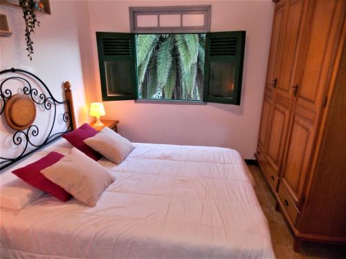 1 dormitorio con 1 cama blanca y ventana en Casa Fasnia Nature, en Fasnia